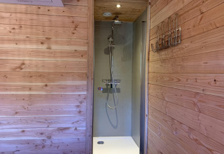 Ducha con paredes de madera en la casa del árbol Heydehuis + Jacuzzi en Sandberghe, Países Bajos.