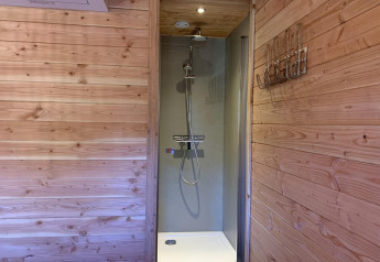 Dusche mit Holzwänden im Heydehuis + Jacuzzi Baumhaus bei Sandberghe in den Niederlanden.