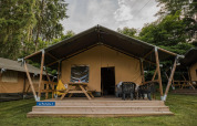 Tienda safari La Rochette con terraza de madera en Beter Uit Holiday Park Walsdorf, Luxemburgo, entre árboles.