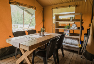 Interior de la tienda Safari La Rochette con mesa de madera, sillas y estantería en Walsdorf, Luxemburgo.