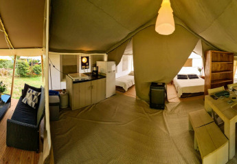Interior de una tienda safari de lujo con sala, cocina, dormitorios y comedor en Eifel, Luxemburgo.