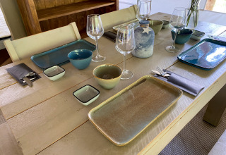 Mesa puesta en la tienda safari Lodge Eifel de Beter Uit Holiday Park Walsdorf, Luxemburgo, con vajilla moderna.