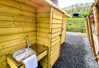 Fregadero exterior y estructura de madera junto a la tienda Lodge Eifel en Beter Uit Holiday Park Walsdorf, Luxemburgo.