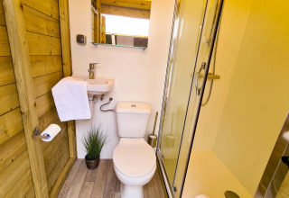 Baño moderno en la tienda Lodge Eifel, Beter Uit Holiday Park Walsdorf, Luxemburgo, con ducha y aseo.