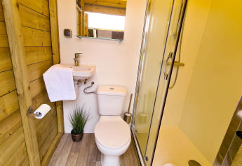 Baño moderno en la tienda Lodge Eifel, Beter Uit Holiday Park Walsdorf, Luxemburgo, con ducha y aseo.