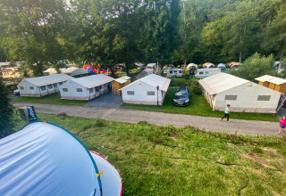 Vista de la tienda Lodge Eifel en Beter Uit Holiday Park Walsdorf, Luxemburgo, con tiendas y caravanas.