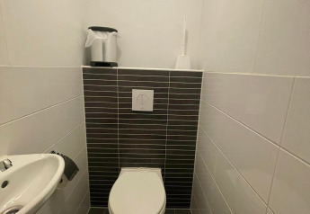 Comfort Lodge - Dogs allowed: moderne toiletruimte met hangtoilet, wastafel en donkere tegels.