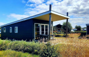 Moderno lodge Comfort en Kompas Camping - Westende en Bélgica, con terraza y rodeado de naturaleza.