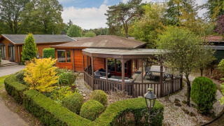 Acogedora Veluwe lodge en Bungalowpark Het Verscholen Dorp, Países Bajos, rodeada de vegetación y árboles.