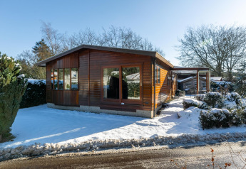 Veluwe lodge, een tiny house van hout in de sneeuw bij Bungalowpark Het Verscholen Dorp in Nederland, winter.