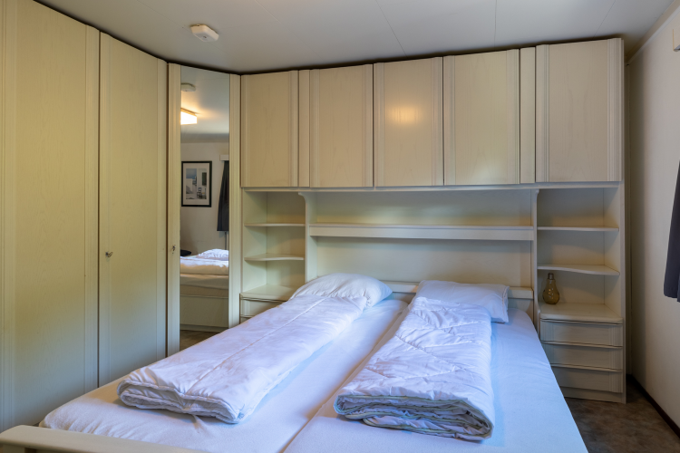 Schlafzimmer in der Veluwe Lodge im Bungalowpark Het Verscholen Dorp in den Niederlanden mit Kleiderschränken.