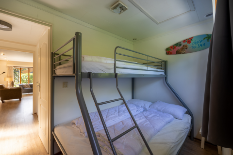 Kamer met een stapelbed in een Veluwe Lodge in Bungalowpark Het Verscholen Dorp, Nederland, daglicht.