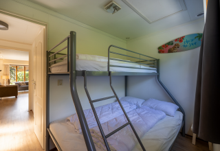 Camera con letto a castello nella Veluwe Lodge al Bungalowpark Het Verscholen Dorp nei Paesi Bassi, luce naturale.