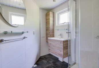 Salle de bain moderne et compacte à la Veluwe Lodge, Bungalowpark Het Verscholen Dorp, Pays-Bas, armoire bois.