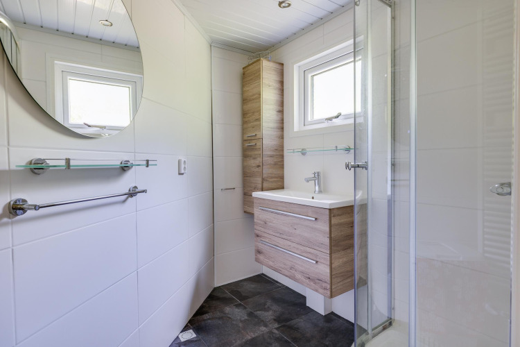 Moderno baño pequeño en Veluwe Lodge, Bungalowpark Het Verscholen Dorp, Países Bajos, con muebles de madera.