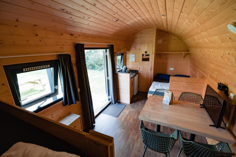 Vista interior de la cabaña Woodlodge en Camping the Noetselerberg en los Países Bajos con mesa de comedor.