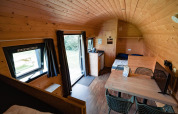 Interieur van de houten Woodlodge bij Camping de Noetselerberg in Nederland met zicht op tafel en bed.