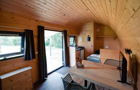 Interior de la Woodlodge en Camping the Noetselerberg, Países Bajos, con paredes de madera y muebles modernos.