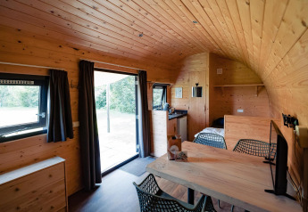 Interieur van Woodlodge bij Camping de Noetselerberg in Nederland met houten wanden en modern meubilair.