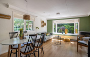 Sala luminosa y moderna en Heide lodge de Bungalowpark Het Verscholen Dorp en los Países Bajos, con grandes ventanas.