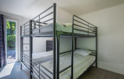 Zimmer mit Etagenbetten und hellem Interieur in der Heide Lodge im Bungalowpark Het Verscholen Dorp, Niederlande.