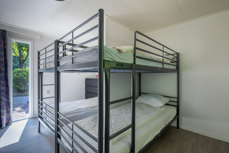 Room with bunk beds and bright interior at Heide lodge in Bungalowpark Het Verscholen Dorp, Netherlands.