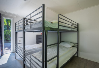 Zimmer mit Etagenbetten und hellem Interieur in der Heide Lodge im Bungalowpark Het Verscholen Dorp, Niederlande.