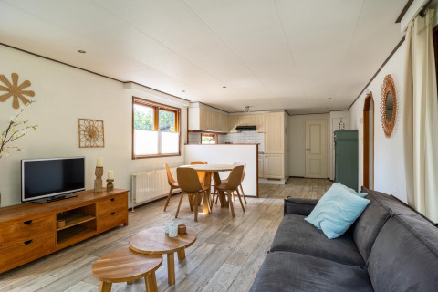 Sala y comedor en la Heide lodge en Bungalowpark Het Verscholen Dorp, Países Bajos, con decoración moderna.