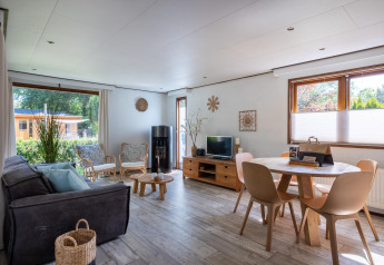 Luminoso soggiorno accogliente presso Heide lodge al Bungalowpark Het Verscholen Dorp, Paesi Bassi, con arredi moderni.
