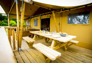 Buiten eetruimte bij een safaritent genaamd Glamping Lodge op Holiday Park Duinhoeve in Nederland.