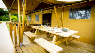 Zona de comedor exterior en una tienda safari llamada Glamping Lodge en Holiday Park Duinhoeve en los Países Bajos.