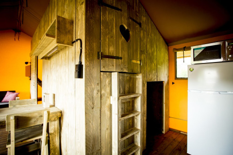 Innenansicht des Glamping Lodge Safarizelts mit rustikaler Holzkonstruktion und moderner Ausstattung in Holland.