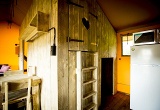 Innenansicht des Glamping Lodge Safarizelts mit rustikaler Holzkonstruktion und moderner Ausstattung in Holland.