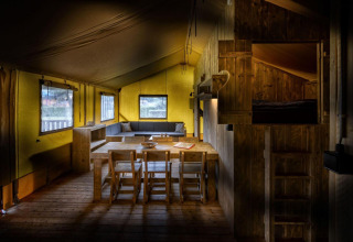 Interieur van een safaritent Glamping Lodge met houten meubels bij Holiday Park Duinhoeve, Nederland.