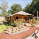 Safari tent at Holiday Park Gelloo in the Netherlands, with wooden porch, greenery, and outdoor seating area.