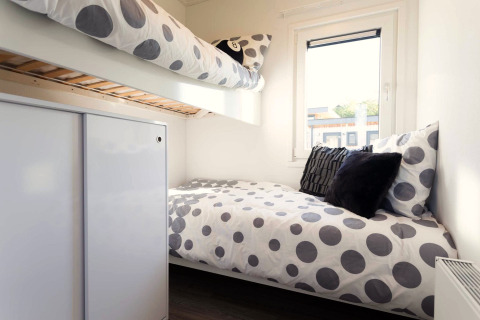 Chambre de lodge moderne avec lits superposés, literie à pois et fenêtre chez Z Module Wellness, Résidence Valkenburg.
