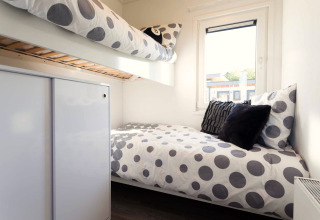 Chambre de lodge moderne avec lits superposés, literie à pois et fenêtre chez Z Module Wellness, Résidence Valkenburg.
