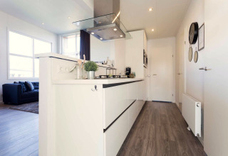 Cuisine moderne et salon d’un lodge à la Résidence Valkenburg, Pays-Bas, au design lumineux et épuré.
