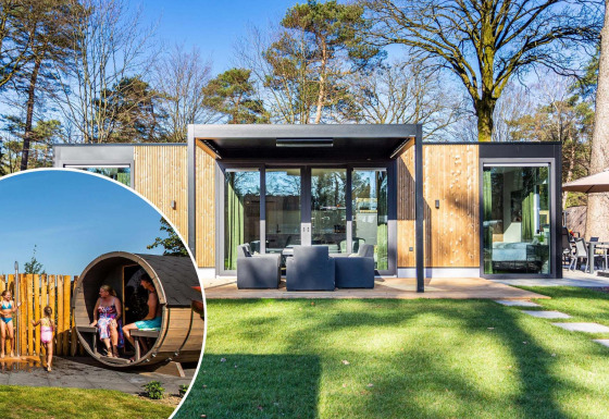 Lodge Veluwe Hoeve Sauna moderno con grandes ventanales, terraza y personas disfrutando de una sauna exterior.