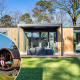 Moderne Veluwe Hoeve Sauna-lodge med store vinduer og terrasse, folk nyder sauna og udendørsbruser.