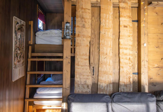 Træhytteinteriør med køjesenge, træpanelvægge og hyggelig atmosfære i Cosy Cabins, Limburg-skoven.