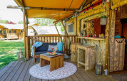 Gemütlicher Außenbereich eines Safarizeltes, Dune Lodge in Sandberghe, Niederlande, mit Holzbar.