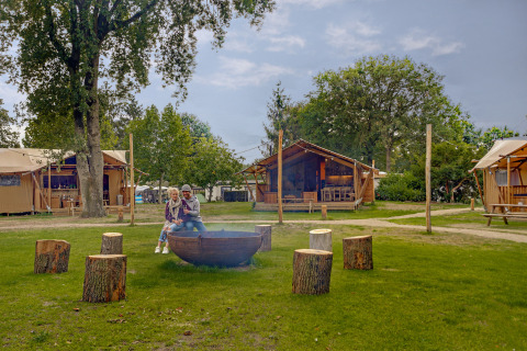 Älteres Paar sitzt am Feuerplatz vor dem Safari-Zelt Dune Lodge im Sandberghe, Niederlande.