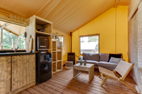 Inde i Dune Lodge safari teltet på Sandberghe, Holland, med rustik stue og fuldt udstyret køkken.