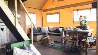 Indretning af Beach Lodge Big ved Duynpark Het Zwanenwater med rustikke møbler og hyggelig atmosfære.