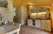 Cucina rustica in legno in una tenda safari a Dune Lodge, Sandberghe, Paesi Bassi, con tavolo da pranzo.