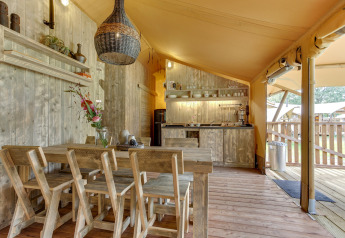 Interno di una tenda safari con area pranzo e cucina presso Dune Lodge, Sandberghe, Paesi Bassi.