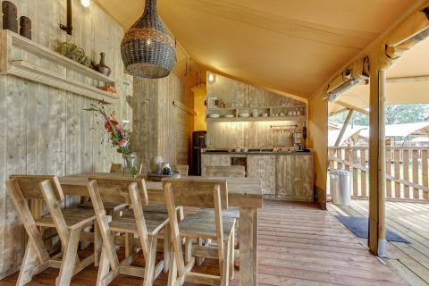 Interno di una tenda safari con area pranzo e cucina presso Dune Lodge, Sandberghe, Paesi Bassi.