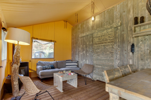 Intérieur de la tente safari Dune Lodge à Sandberghe aux Pays-Bas avec mobilier confortable et rustique.