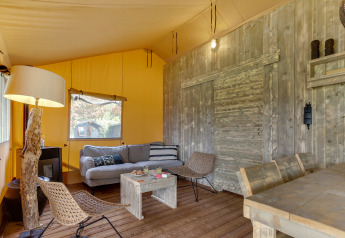 Binnenkant van de safaritent Dune Lodge bij Sandberghe in Nederland, met karaktervolle houten meubels.